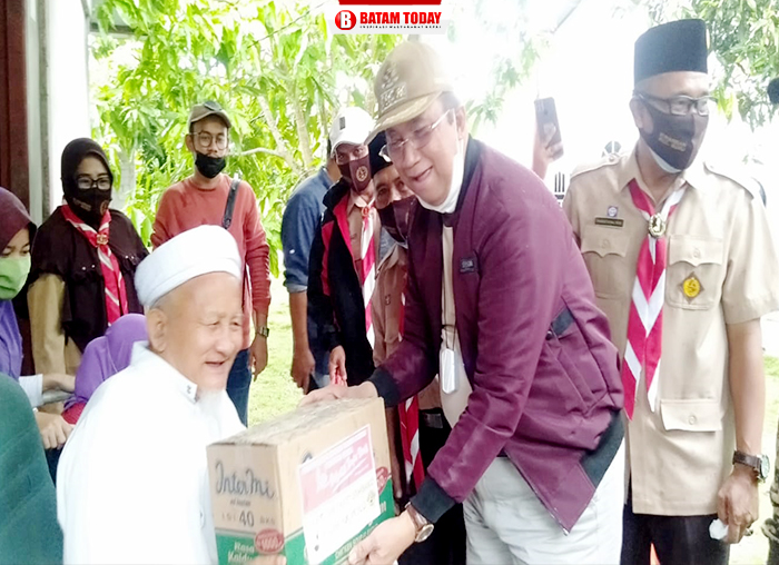Ka. Kwarcab Pramuka Kabupaten Karimun, H. Anwar Hasyim saat menyerahkan bantuan paket sembako kepada salah seorang warga di Kecamatan Buru